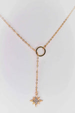 Gold star and circle pendant cross necklace on white background