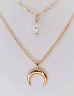 Double strand gold necklace featuring moon and pearl pendants