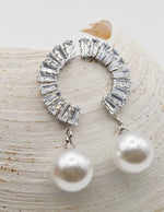 crystal_pearl_arc_ear_wings pair styled on seashell background with pearls