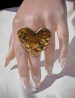 Close-up of bold heart shape ring reflecting light