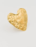 Sculpted gold heart ring on white background – hammered metal texture