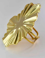Side view of golden adjustable ring with textured starburst design