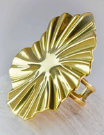 Gold leaf-shaped brooch on a light background