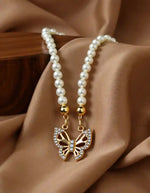Close-up of butterfly pearl necklace with crystal details