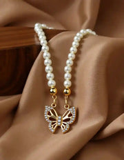 Close-up of butterfly pearl necklace with crystal details