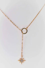 Gold star and circle pendant cross necklace on white background