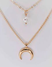 Double strand gold necklace featuring moon and pearl pendants