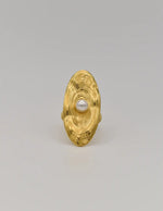 Close-up of golden ring surface showing ripple-inspired design