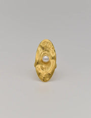 Close-up of golden ring surface showing ripple-inspired design