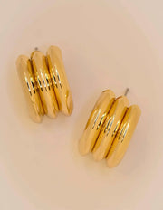 Close-up of polished triple curve gold conch earrings
