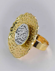 Gold ring with textured design on a light gray background