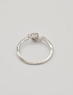 Angled shot of the Silver Glow Heart Eternity Ring on a seashell, showing the heart‑shaped centre stone and elegant pave setting; a clean girl jewellery 2025 favourite and thoughtful gift for her jewellery