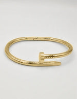 Luxury gold twist nail bangle bracelet, modern Canadian fashion accessory.