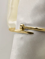 Close-up of gold twist nail bangle bracelet with smooth polished finish, Canadian chic.